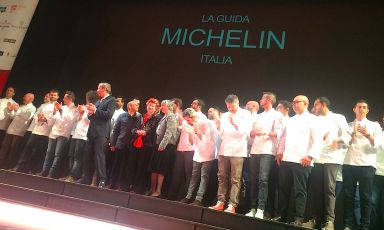 Foto-ricordo, sul palco del Teatro Regio di Parma, per i nuovi stellati dell'edizione 2017, la numero 62, della guida Michelin Italia. Al centro si riconoscono, dietro al direttore mondo Michael Ellis, i tristellati Heinz Beck, Annie Feolde e Nadia Santini. Terzo da sinistra invece, Enrico Bartolini, il mattatore della giornata. Quattro stelle per lui grazie a tre insegne tutte nuove.
