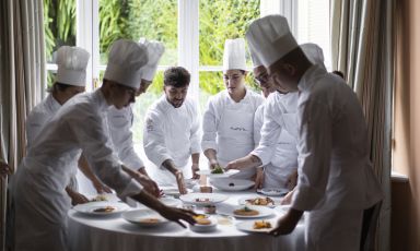 Lo chef Antonio Romano, al centro, con la sua brigata a un tavolo del ristorante Nove del Villa della Pergola, ad Alassio (Savona)
