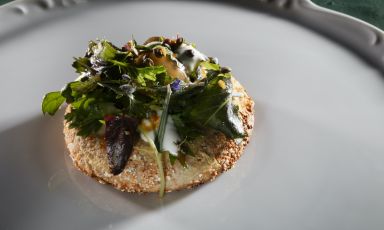 La "Quinta" Stagione, eccellente pizza portata da Roberto Davanzo a Identit&agrave; Milano 2026: impasto a base di lenticchie, grano saraceno e miso di ceci, topping di hummus di cicerchia e fondo vegetale, yogurt di kefir, misticanza selvatica, sferificazione di fagiolo Poverello alla pignata, lenticchie soffiate e gel di bergamotto. Tutte le foto sono di Brambilla-Serrani
