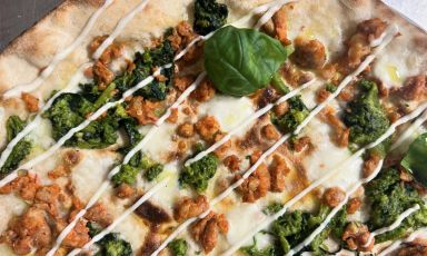 Rape fresche ripassate in padella, fior di latte, salsiccia fresca e fonduta di pecorino romano: una delle specialità dal bordo inesistente e base scrocchiarella alla pizzeria Edrì, storie di farina di Rende (Cosenza)
