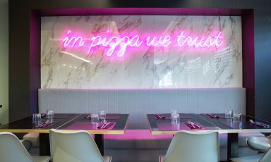 In pizza we trust, Noi crediamo nella pizza, il celebre neon rosa che ha subito contraddistinto la pizzeria di Pier Daniele Seu in via Angelo Bargoni 10-18 a Porta Portese a Roma

