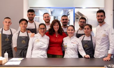 Foto di gruppo al pass: Lara Gilmore al centro, tra Sabrina Russo e Karime Lopez, e intorno la brigata di cucina di Identità Golose Milano
