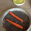 Dried carrot and sorrel, Carote grigliate a fuoco lento per 14 ore, disidratate e servite su polvere di fieno. Si intingono nell'emulsione di acetosella accanto. Un grande piatto perché di inattesa, energica acidità