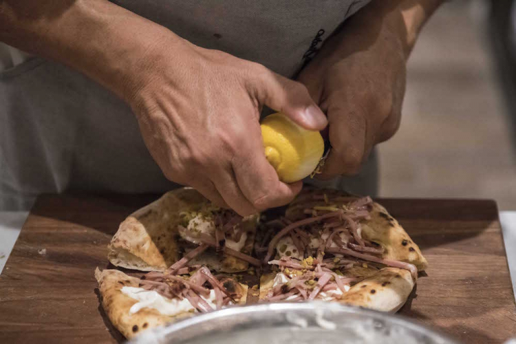 La finitura della pizza di Franco Pepe
