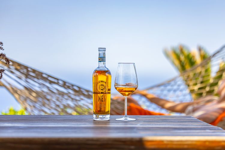 Nes 2022 – Carlo Pellegino
Questo passito colpisce per un colore oro antico tendente all’ambra e le note di frutta candita, albicocca principalmente, per poi virare verso sfumature di eucalipto e salvia. Un calice dall’equilibrio perfetto, mai stucchevole e con un potenziale evolutivo davvero importante. All’assaggio il fico secco e la pesca sciroppata completano il quadro olfattivo con grande rispondenza