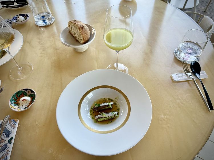 Piada con i sardoni: piadina cotta al vapore, alici marinate fresche, maionese di rucola alla brace (che ricorda il profumo della piada in cottura), brodo di cipolle caramellate (un elemento chiave della piadina condita così). Si accompagna con Estratto di mela verde con infuso di salvia. Grande inizio, che tocca con rispetto uno degli street food più conosciuti e amati