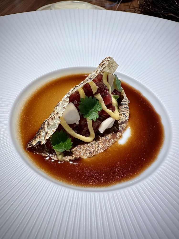 Tartare di pecora avvolta dalla yuba (una pellicola che si forma dalla coagulazione del latte di soia), fragoline di bosco in conserva, mandorle marinate, pimpinella, salsa bernese e fondo di cottura della pecora: dolcezza e carattere