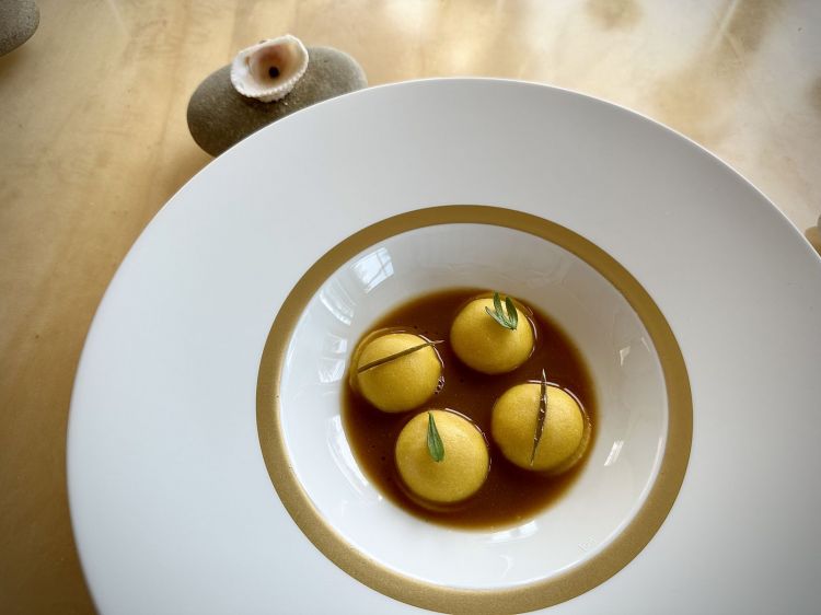 Bottoni “ricchi e poveri”: sono ripieni di zuppa di lumachine di mare (ingrediente umile) e foie gras (ingrediente opulento), serviti in una zuppa di lumachine, con sopra paccasassi sott’aceto e scottati freschi. Prima di degustarli, si deve mangiare una bacca di pepe verde in salamoia (una tecnica appresa da Gianni Frasi). Questo aiuta il palato con sapidità e piccantezza, come condimento indiretto dei bottoni.