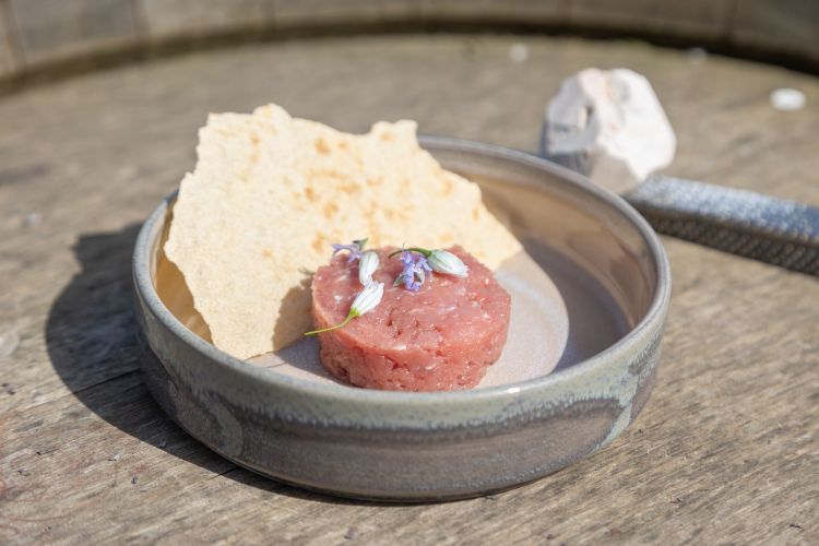 I due piatti di street food proposti da Giuliano Baldessari: Battuta di agnello, colatura di alici e pietra caolina e, sotto, Bresaola di pomodoro, rucola e grana