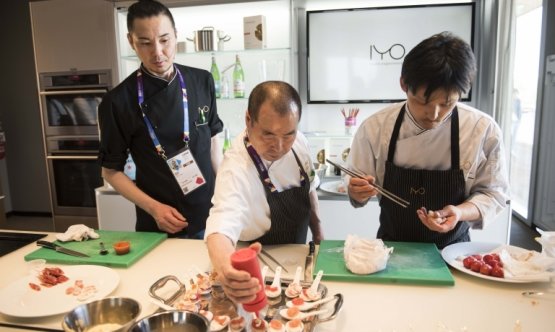 Lo chef Haruo Ichikawa, in mezzo a due assistenti, durante una recente lezione nel temporary restaurant di Identità Expo S.Pellegrino
