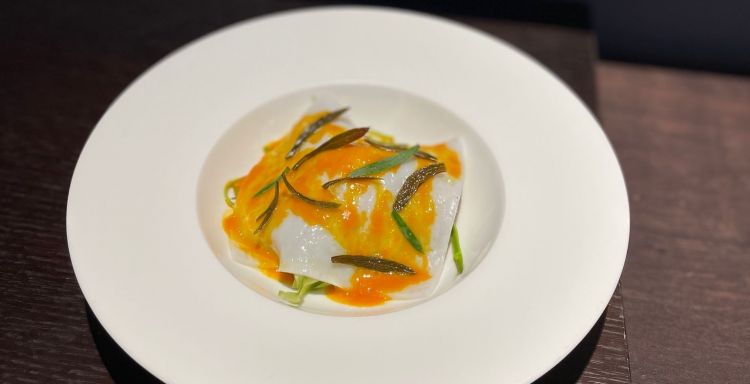 Seppia, carota, asparago
Alessio Magistro
Sopra c'è un velo elastico di seppia cruda, frullata, setacciata e cotta al vapore, con una glassa di carota e del finocchietto di mare da Messina, il luogo d'origine del cuoco. Sotto la seppia, una carota d'Ispica centrifugata e ridotta con noce di burro e punte d'asparago bianco marinato in una salamoia. Servito tiepido, un piatto molto riuscito per l'intreccio di dolcezze, mineralità e masticature diverse e appaganti
