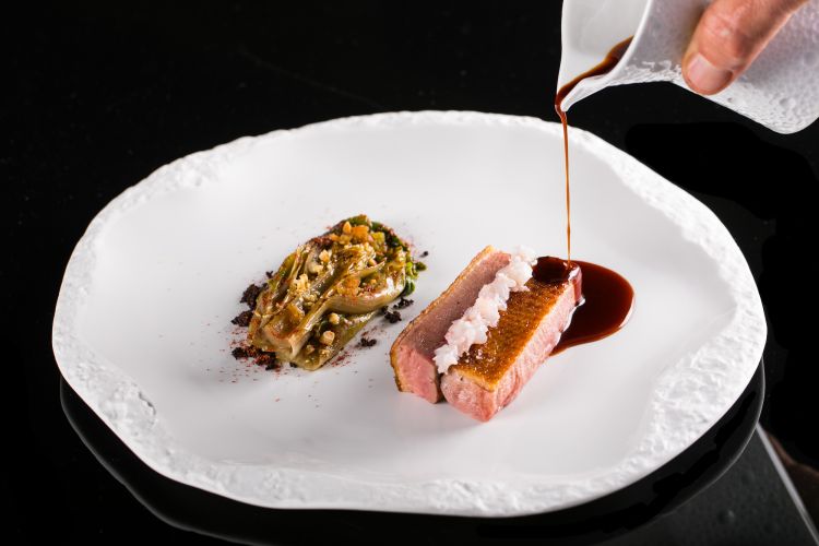 Petto d’anatra: marinato in pasta tandoori, viene servito con alla base un crumble al cacao, a lato del cavolo cappuccio cotto nel grasso d’anatra e del kiwi. Sopra al petto si trova una tartare di scampi e una crema di pinoli sbianchita con il latte. A completare, un fondo di anatra e scampi (totalmente antispreco). Apreda sa anche essere altamente classico, richiamando la più nobile cucina francese. (foto Omnigraf Italia)