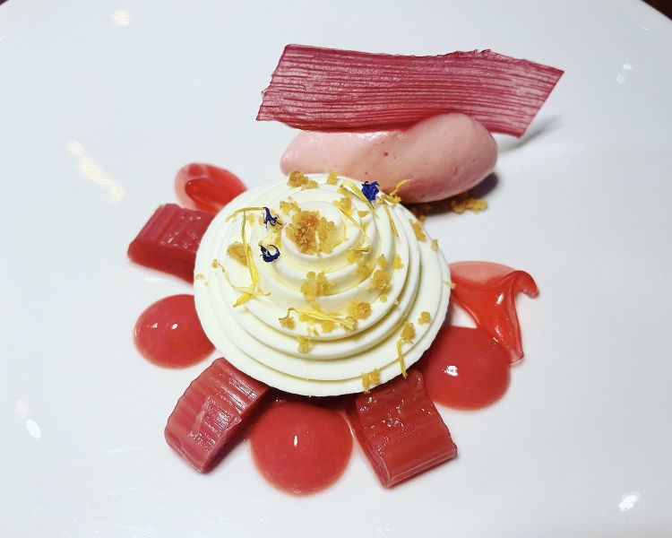 Rabarbaro e zafferano: Cheesecake aromatizzato al cardamomo, mezza sfera allo zafferano coperta da una namelaka al cioccolato bianco, rabarbaro a pezzetti, sciroppo fiore Ibisco, sorbetto e chips al rabarbaro