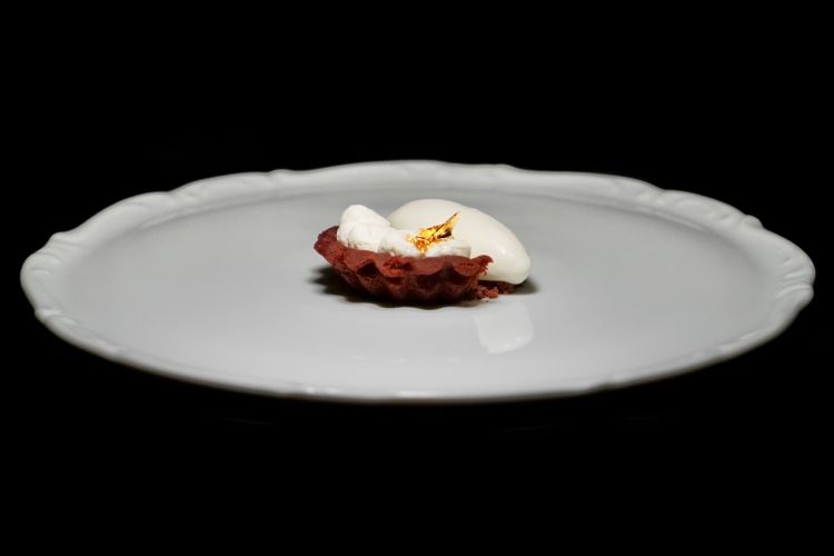 Dopo il predessert (Melone, levistico e tonica: un cubo di melone marinato viene servito con foglie di levistico, conosciuto anche come sedano di montagna, e una tonica prodotta dal ristorante) si chiude con&nbsp;Crostatina di scalogno ossidato, vermouth, lampone e lavanda: lo scalogno, trasformato dall&rsquo;ossidazione, sviluppa una dolcezza profonda e quasi caramellata. Il vermouth rosso aggiunge note vinose e speziate, l&rsquo;aceto di lampone porta acidit&agrave; e il gelato alla lavanda chiude con un profumo floreale deciso
