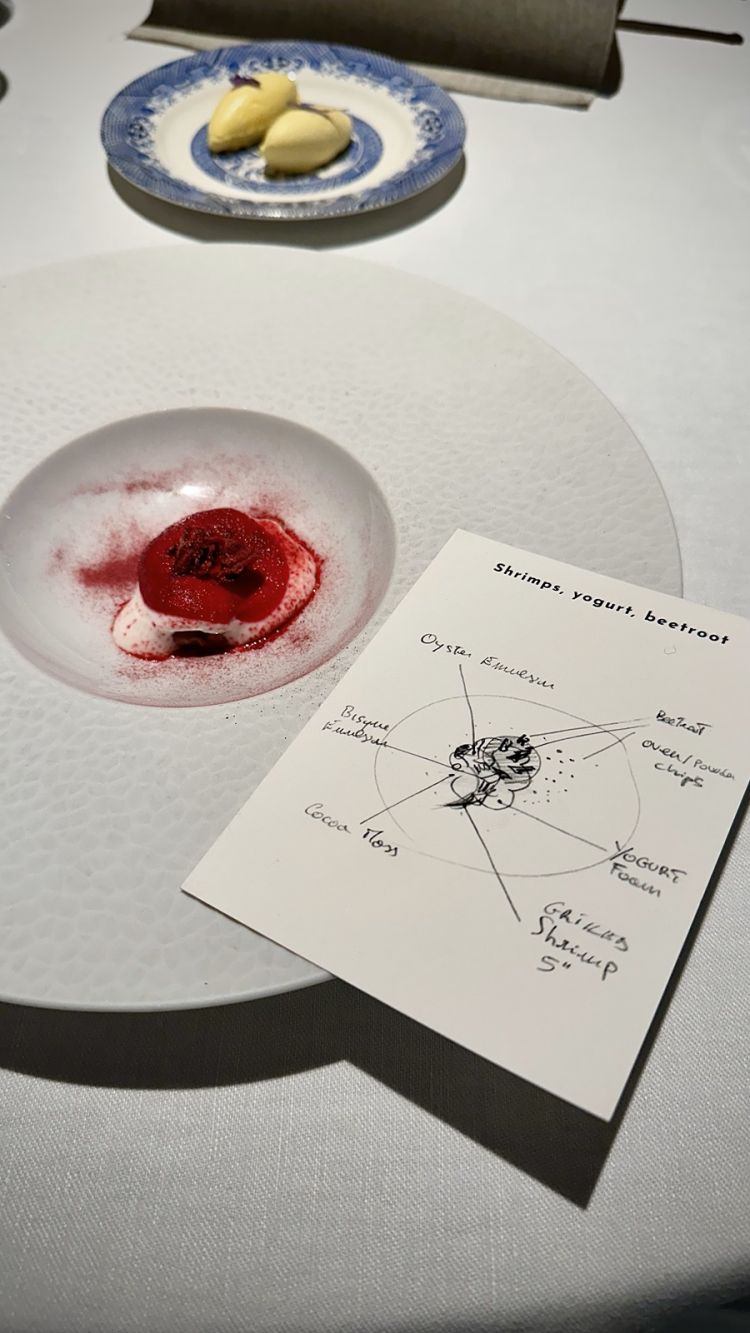 Gambero rosso di Sicilia (passa alcuni secondi sulla brace viva), massa di cacao spennellata, emulsione di ostriche e bisque, yogurt e rapa rossa. Due curiosità: per ogni portata del menù, viene dato un cartoncino con lo schizzo preparatorio del piatto stesso, che, in questo caso, è molto caro allo chef, essendo il primo nato post lockdown in epoca Covid, alla riapertura del 2 giugno 2020