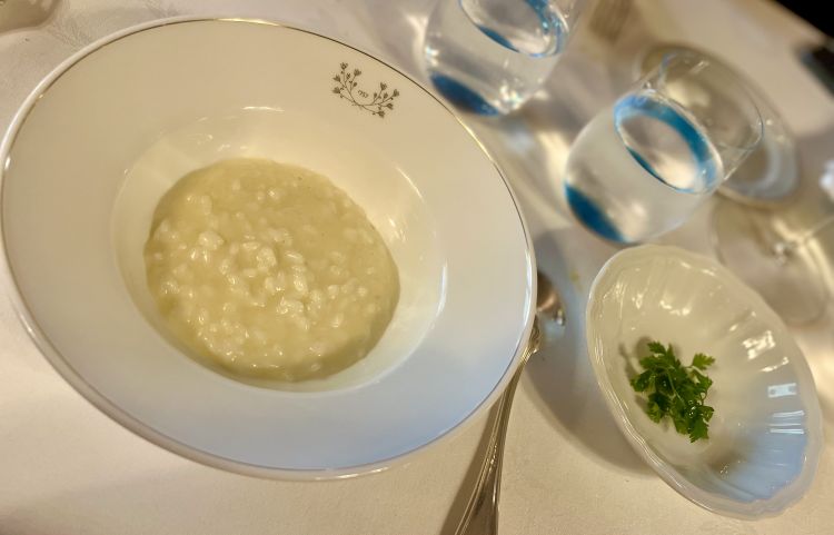 Hazelnut rice 
A rice (overcooked, as per Piedmontese tradition) whipped only with Gobino hazelnut oil, no butter or parmesan. On the small plate next to it, the acidity of chervil with fennel seed vinegar interrupts the voluptuousness
