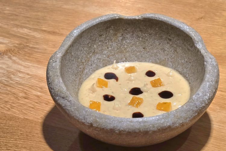 Risotto al fieno. Piatto di grande complessità: Carnaghi lascia affinare il normanno (tipo di pecorino semistagionato affinato con aceto balsamico) a contatto con il fieno per un mese, così da arricchirne gli aromi. Altro fieno viene prima passato sul barbecue, poi immerso nel latte per ottenere una fonduta dalle note affumicate. Normanno e fonduta si incontrano nella mantecatura di un risotto che trova equilibrio e freschezza grazie a cedro sottosale, crema di cedro e un delicato fondo vegetale. Un piatto complesso, vibrante e cerebrale, in cui il lungo lavoro tecnico emerge con chiarezza, lasciando al palato un ricordo profondo e persistente
