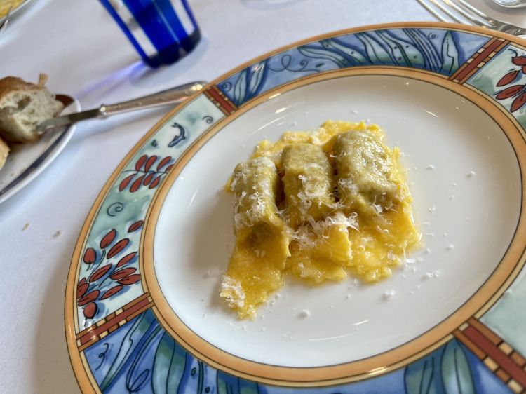 Tortelli di zucca al burro e parmigiano (zucca, amaretti, mostarda, Parmigiano Reggiano)
Uno dei piatti firma della cucina italiana dell'ultimo mezzo secolo. «In realtà», racconta Antonio Santini, «i tortelli li faceva già buoni mia nonna Teresa. Poi mia mamma Bruna l'ha fatto ancora più buono, Nadia ancora meglio e questo è di Giovanni: la selezione della pasta è persino più accurata, ha una consistenza che esprime meglio l'armonia della zucca americana, che prendiamo sempre nella zona tra Viadana e Sabbioneta. Quest'anno sono straordinarie ma la qualità non è costante negli anni, naturalmente, dipende dal meteo». In abbinamento, i ragazzi di sala servono un riesling alsaziano Clos Saint Landelin 2018
