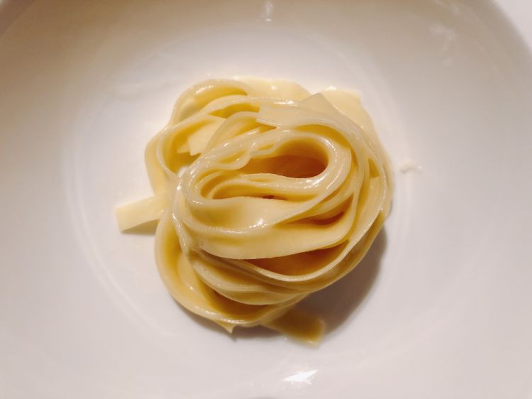 Tagliatelle, Parmigiano and lemon: it sounds simple, but the sauce is made without any added fat, working the Parmigiano with water, to maintain a lightness that enhances the pasta, hand-rolled on wood. Complete with lemon zest, to give fragrance
