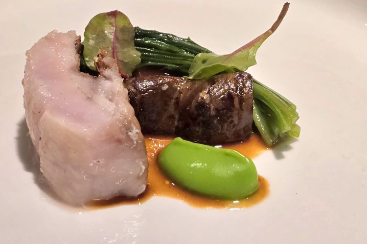 Scorfano cotto alla brace sulla sua pelle servito con topinambur, cicoria in vinaigrette, crema di limone e menta e jus di fondo di pesce. La griglia esalta la parte più intensa dello scorfano e la grassezza trova equilibrio nella freschezza erbacea e nella vivacità agrumata. Potente e saporito il fondo
