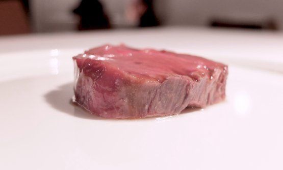 Manzo torbato: la prima cosa che colpisce è il profumo quasi d’incenso che sprigiona. La parte olfattiva della carne viene creata sia con un’affumicatura espressa sia utilizzando un whisky di dieci anni torbato (“quasi farmaceutico”, specifica lo chef). Alla base c’è un gel di vitello estratto dai succhi del manzo con aggiunta di pepe e spezie (rosmarino, timo, aglio ed altre). La patata è lessa, e ha un estratto di patata sopra. La cottura della carne avviene in un brodo a temperatura controllata, riposa 3/4 giorni in modo che si assesti e resti cremosa al palato, mantenendo al contempo struttura e consistenza. È il rispetto della proteina: il colore resta roseo ma il disco di carne non perde neanche un grammo di sangue (provate a tagliarla e vedrete con i vostri occhi), perché tutte le proteine riescono a gestire i succhi all’interno della struttura
