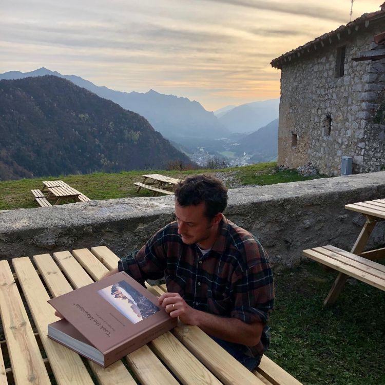 Giacomo Perletti mentre legge il libro Cook the Mountain di Norbert Niederkofler
