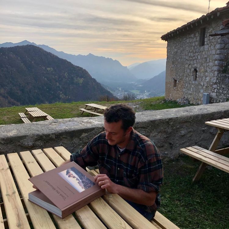 Giacomo Perletti mentre legge il libro Cook the Mountain di Norbert Niederkofler
