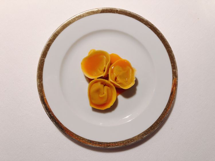 Pumpkin tortelli: this is one of the symbols of fresh Italian stuffed pasta, seen through Niko Romito's eyes, i.e. as an unusual predessert that plays on the natural sweetness of the pumpkin. Two types of pumpkin are used: the (more watery) Violina for the creamy base, the (sweeter) Piacentina for the filling
