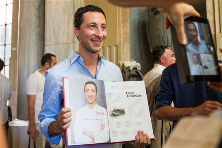Abbattista posa con aperte le pagine a lui dedicate, in 100 chef x 10 anni (Mondadori)
