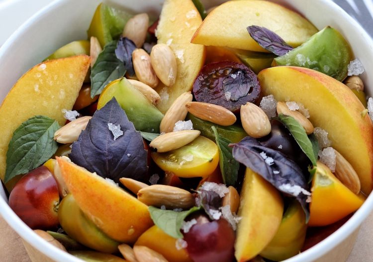 Salad with six varieties of tomatoes, white and yellow peaches, green and red basil, toasted almonds and flakes of unrefined salt from the Argentinian Patagonia 
