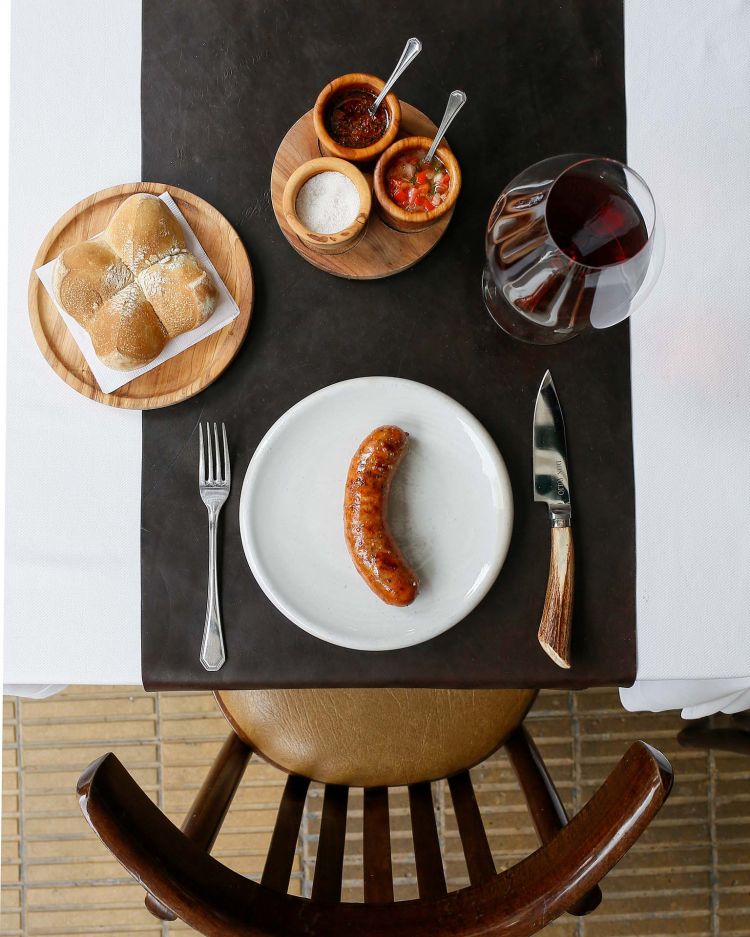 Il benvenuto al Don Julio: chorizo, di elaborazione propria, pane con grasa de vaca, salsa criolla e chimichurri e un calice di vino rosso rigorosamente argentino