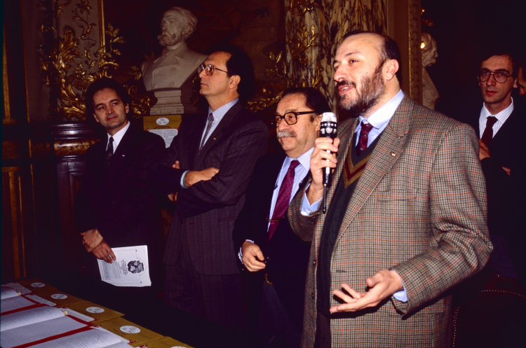 Petrini col microfono nel 1989 a Parigi; accanto a lui c'è Folco Portinari
