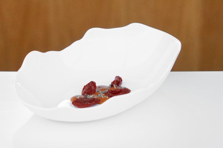 Datterino: datterino concentrato, salsa di datterino al vino e acido lattico, origano. I datterini sono cotti nella calce, asciugati e poi marinati. Sono serviti con una salsa di datterino lavorata con acido lattico, vino rosso e origano. La pienezza del pomodoro nella sua essenza, l'origano come variante che rimanda al nostro dna gastronomico. Texture e capacità di controllo