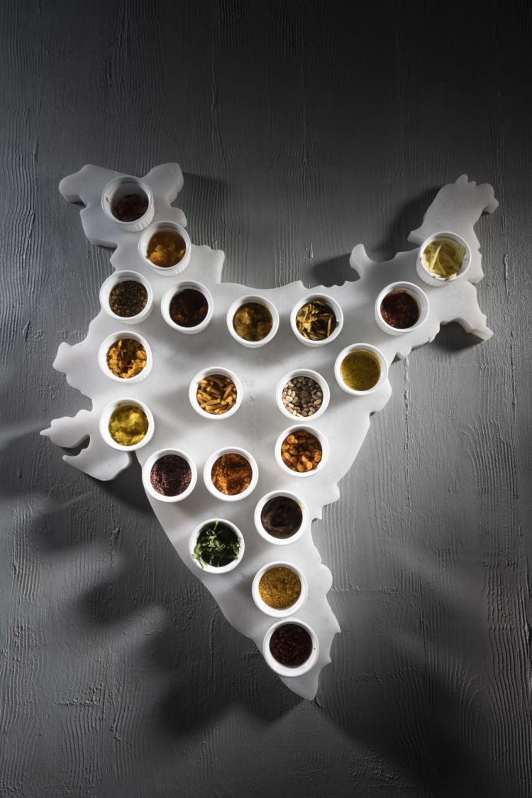 Nel piatto di Saini, ingredienti simbolo contenuti in piattini posizionati sulle rispettive culle geografiche
