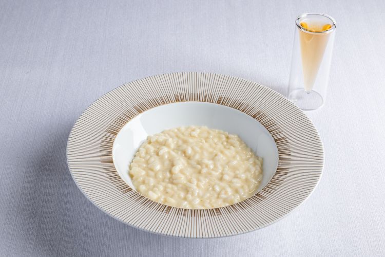Risotto al caprino di Cavalese stagionato in fossa e affinato al Walden Bitter - Alessandro Gilmozzi
Un piatto che esprime il proverbiale perfezionismo di chef Gilmozzi, che scende in Romagna per affinare in fossa il caprino delle sue parti, mesi dopo ri-scende, lo preleva e lo riporta su, marinandolo per altri 6 mesi nell'amaro di sua produzione. Al palato, croste di formaggio si intrecciano a un'amara complessit&agrave;, rinforzata&nbsp;dalla tisana di lato, composta dalle stesse botaniche del bitter
