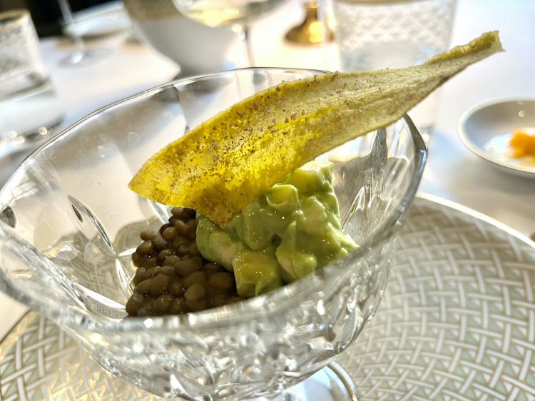 Lenticchie brasate, avocado, banana, noce moscata
Un insieme di ingredienti piuttosto comuni, abbinati in modo curioso. C'è un tocco finale al tavolo di colatura di alici che regala alle comuni consistenze morbide di avocado e lenticchie una piacevole complicazione di sapidità. Un gioco, sembra un cocktail solido
