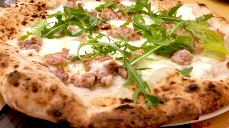 La pizza Affumicata con mozzarella di bufala, salsiccia di Nero Casertano affumicata con legno di quercia e di castagna e rucola a crudo
