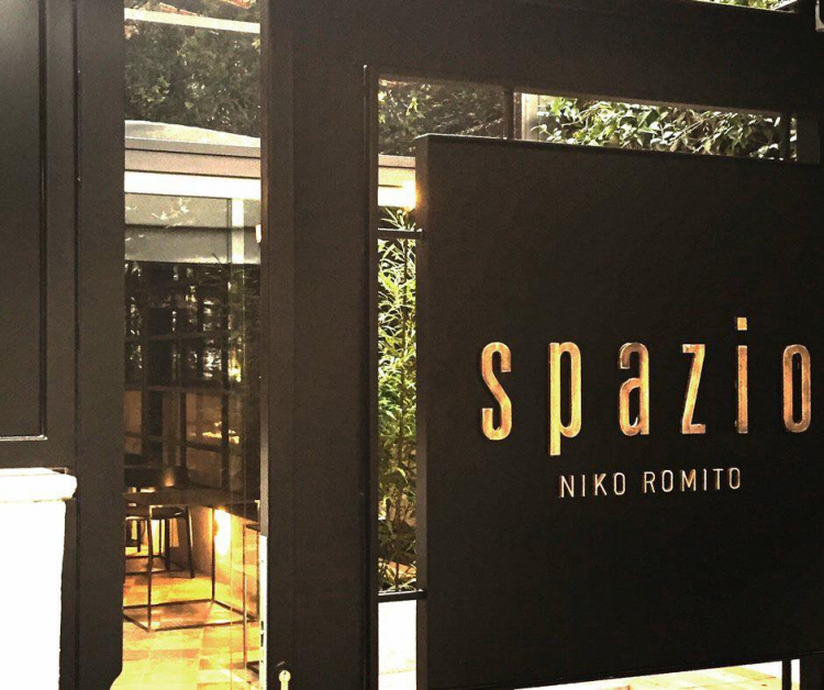 L'entrata di Spazio Roma. La superficie complessiva è di 450 metri quadri divisi in due aree: il ristorante e il caffè, uniti da un corridoio di raccordo e affacciati rispettivamente su via Guido D’Arezzo e su Piazza Verdi. La sala del ristorante ha circa 70 coperti, con un tavolo sociale e la grande cucina a vista dove è possibile mangiare appoggiati al bancone osservando la brigata al lavoro. Spazio Pane Caffè ha un bancone centrale dove sedersi a mangiare oppure ordinare specialità da asporto, e 8 tavoli che affacciano sulla piazza. Anche qui, il laboratorio cucina è a vista
