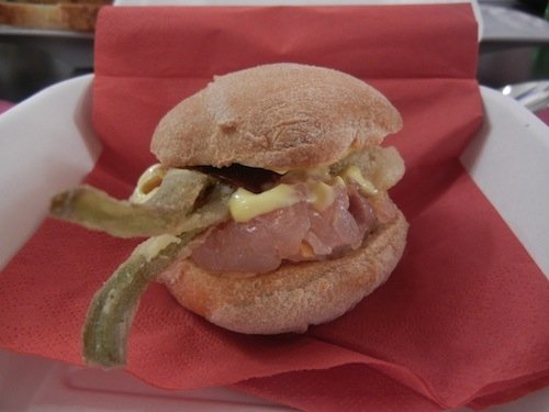 Sandwich with oil mayonnaise, raw fish with lemon zests, tomato and fried artichokes