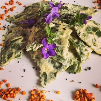 <i>Spinach and dried fruit ravioli with pine seeds, fennel seeds and orange sauce</i>.