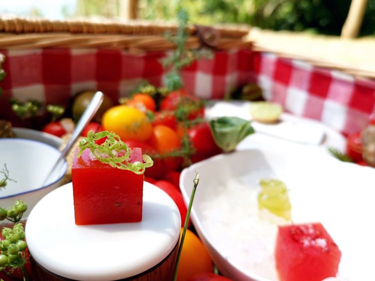 Gelatina al peperone rosso con scorze di lime, tra le tapas di benvenuto servite nei giardini del Mirazur, all'ombra generosa di alberi da frutta
