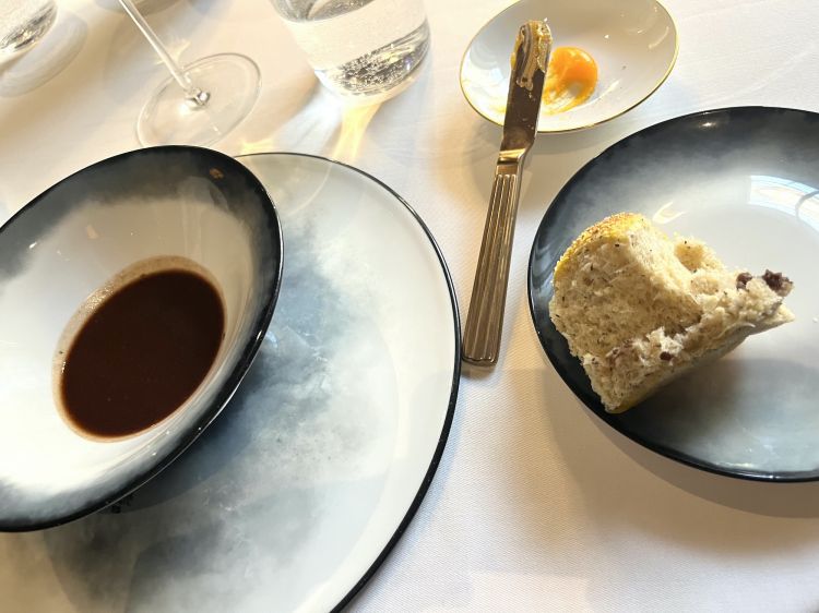 Pane, polenta e bruscitt
Una variazione sui Bruscitt, piatto che vorrebbe i suoi natali a Busto Arsizio, normalmente composto da una carne trita di manzo, dalla grana spessa, che un tempo finiva compagna di generose porzioni di polenta gialla (oggi, specialità meno diffusa di un tempo, si riduce a un morbido ragù cotto nel vino rosso). Luca Sacchi prepara un fondo speciale di verdure scartate dalla cucina, tostato in forno, ridotto e bagnato con vino rosso, finocchietto. Una volta pronto, ci si intinge una focaccia morbida di polenta bianca (mais Biancoperla), farcita con carne brasata di manzo. Irresistibile
