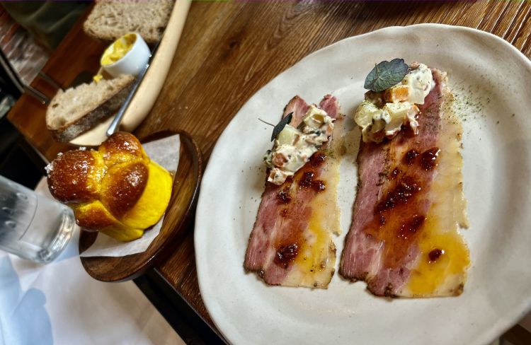 In primo piano, prosciutto cotto di punta di fiocco e insalata russa ricca. Sullo sfondo, Danubio salato alla curcuma e pane con del burro di grasso di bue mantecato (buonissimo)