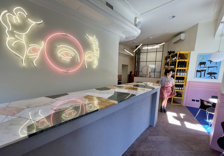 Il bancone dell'Osteria con l’installazione al neon tri-occhio di Patrick Tuttofuoco.