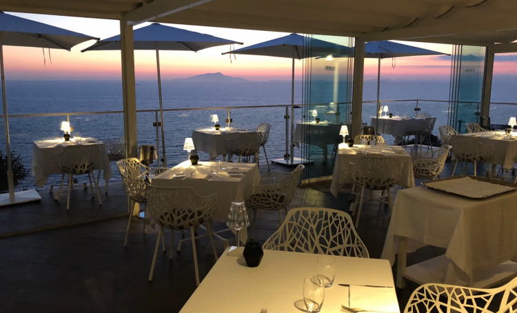 I 20 coperti del ristorante La Terrazza al tramonto. Sullo sfondo, Capri, Ischia e Procida