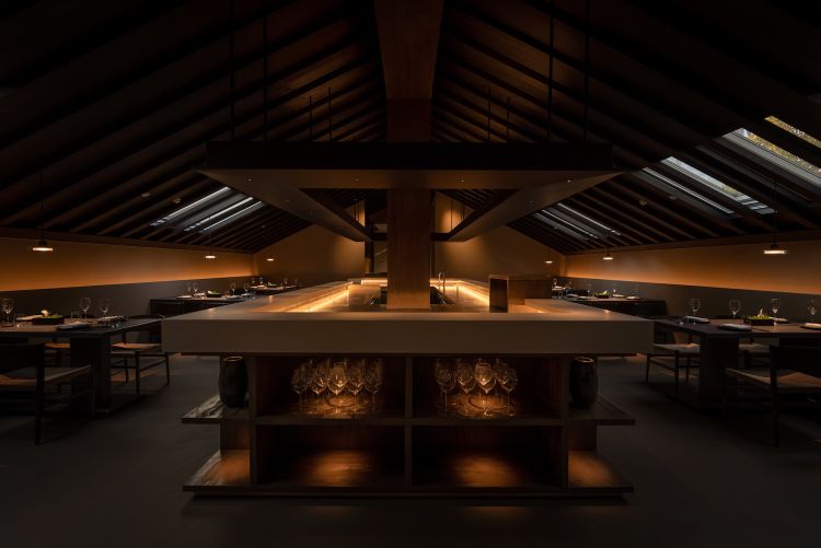 La sala del ristorante by night, un bancone di cucina al centro e 4 tavoli da due per lato. A pranzo filtra una luce importante dai lucernari. Il menu degustazione costa 1.299 rmb (circa 170 euro) senza vini