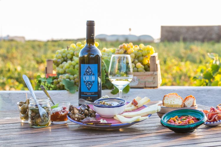 Bianco di Pantelleria Doc
“Sora Luna 2023” - Fabrizio Basile
Uno Zibibbo vinificato secco con una fermentazione e affinamento in acciaio, quindi oltre un semestre di sosta in bottiglia prima della commercializzazione. Un calice che ti sorprende per solarità e freschezza; le note tropicali si fondono con un’elegante florealità ben integrata a sfumature di agrumi e un finale leggermente balsamico molto intrigante. Il concetto dei vini Basile è eroico estremo. Possono essere acquistati solo sull’isola oppure on line