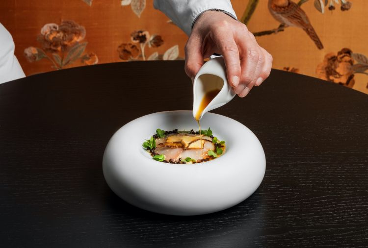 Lampuga in carpaccio: condita con olio al sesamo leggermente piccante, alla base paté di funghi porcini, crema di funghi porcini fermentati, miso e lenticchie, completata con brodo di lampuga ed erba cedrina. (foto Omnigraf Italia)
