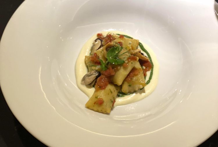 Agnolotti di pasta fresca ripieni di patate e aglio nero con crema di prezzemolo e cozze
