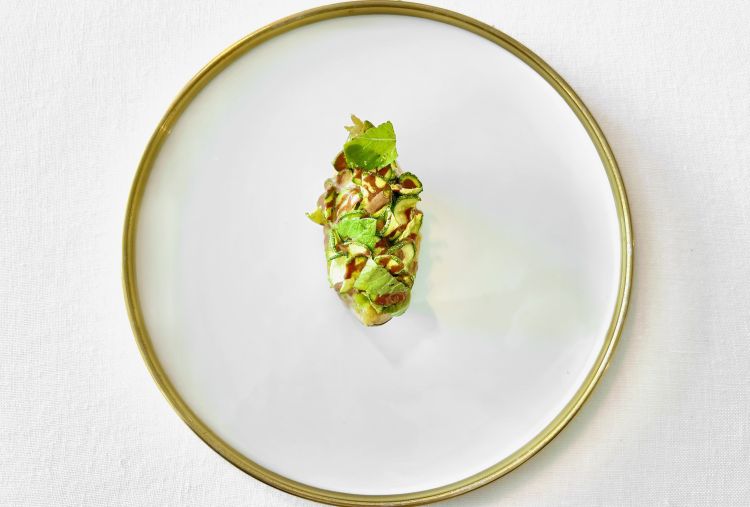 Zucchina, cannella e pepe rosa - Un piatto quasi monoingrediente fondato sulla stratificazione del gusto vegetale. La zucchina compare in quattro tipologie, quattro cotture e quattro consistenze differenti. Sopra interviene il lavoro sulle spezie: gocce di estratto di cannella e del pepe rosa. A dare freschezza arrivano piccole foglie di basilico sacro, varietà dalle leggere note mentolate. Grande densità gustativa, in cui le zucchine rivendicano il proprio ruolo tra le note preponderanti della cannella. Profondo nel finale quando le zucchine rimergono come aroma dominante